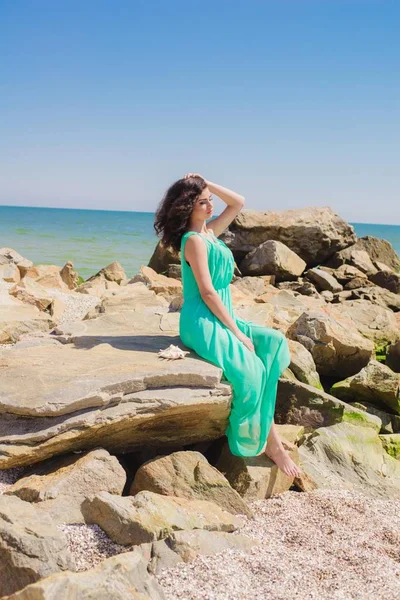 Молодая красивая девушка в длинном платье на пляже — стоковое фото