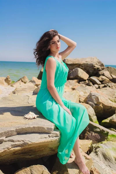 Jovem menina bonita em um vestido longo na praia — Fotografia de Stock