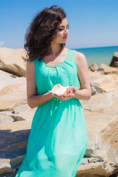Νεαρό κορίτσι στην παραλία το καλοκαίρι με κέλυφος — Φωτογραφία Αρχείου