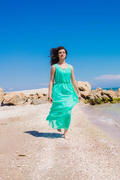 Junges schönes Mädchen in einem langen Kleid am Strand — Stockfoto