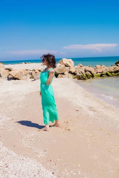 Giovane bella ragazza in un abito lungo sulla spiaggia — Foto Stock