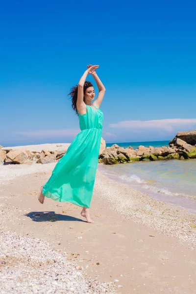 Jovem menina bonita em um vestido longo na praia — Fotografia de Stock