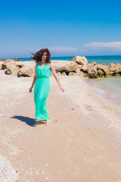 Krásná mladá dívka v dlouhých šatech na pláži — Stock fotografie