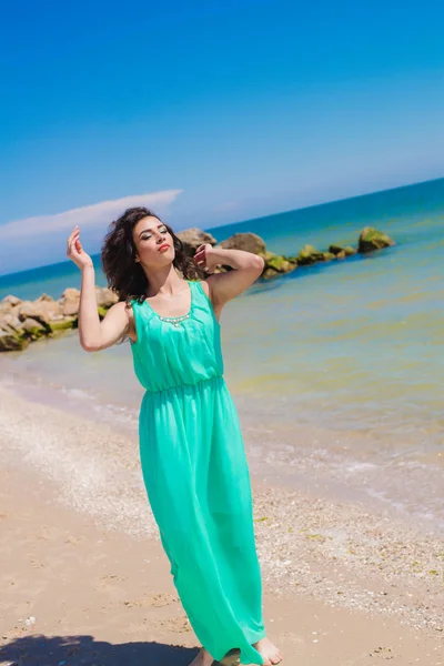 Mooi meisje in een lange jurk op het strand — Stockfoto