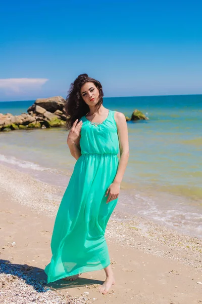 Mooi meisje in een lange jurk op het strand — Stockfoto