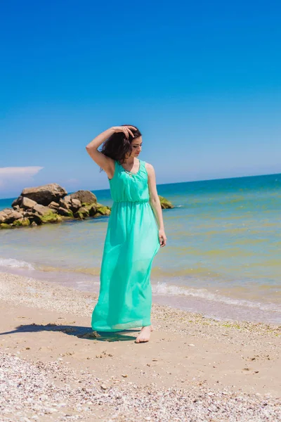 Jovem menina bonita em um vestido longo na praia — Fotografia de Stock