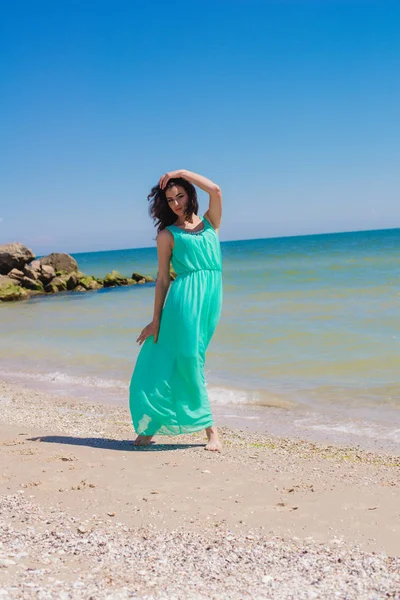 Fiatal gyönyörű lány a strandon egy hosszú ruha — Stock Fotó