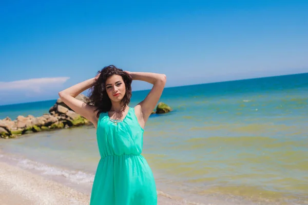 Mooi meisje in een lange jurk op het strand — Stockfoto