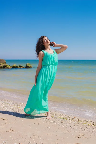 Jovem menina bonita em um vestido longo na praia — Fotografia de Stock