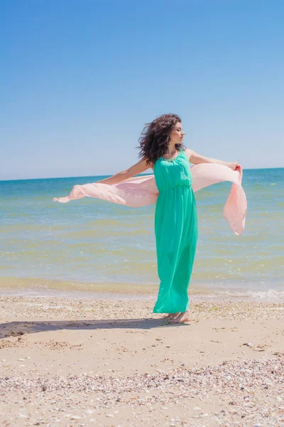 Молодая девушка на пляже летом в красивом платье с летающим шарфом — стоковое фото