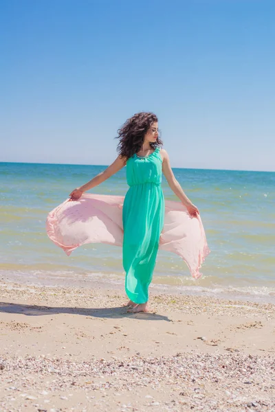 一件漂亮的衣服，用飞的围巾在夏天的海滩上的小女孩 — 图库照片