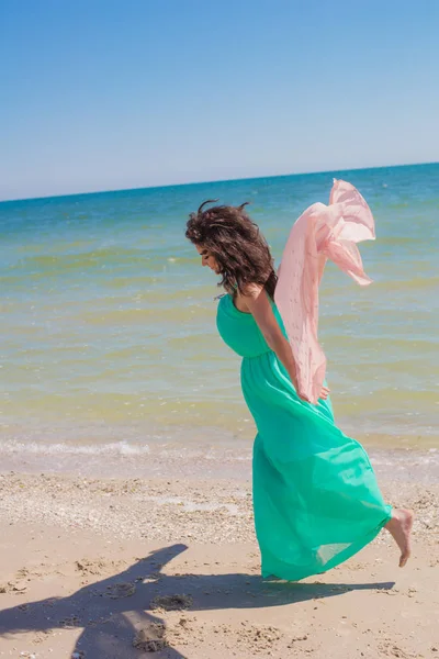 一件漂亮的衣服，用飞的围巾在夏天的海滩上的小女孩 — 图库照片