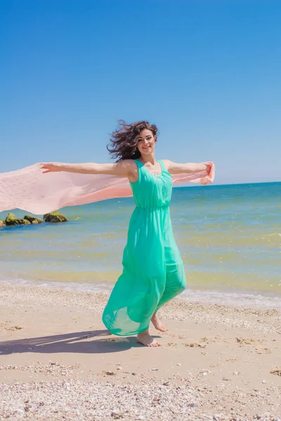 Mladá dívka na pláži v létě v krásné šaty s létající šátek — Stock fotografie
