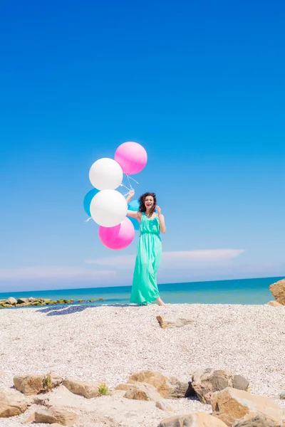 Menina bonita na praia com balões coloridos — Fotografia de Stock