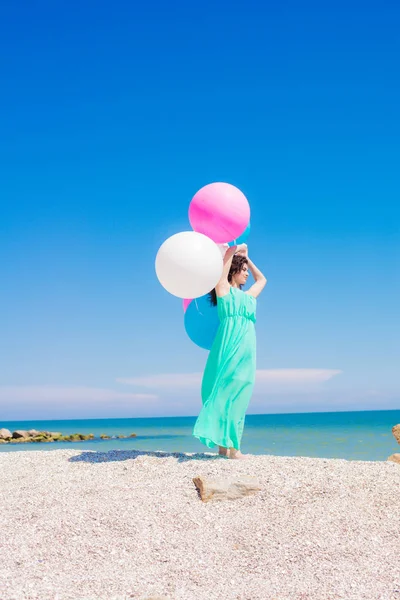 Menina bonita na praia com balões coloridos — Fotografia de Stock