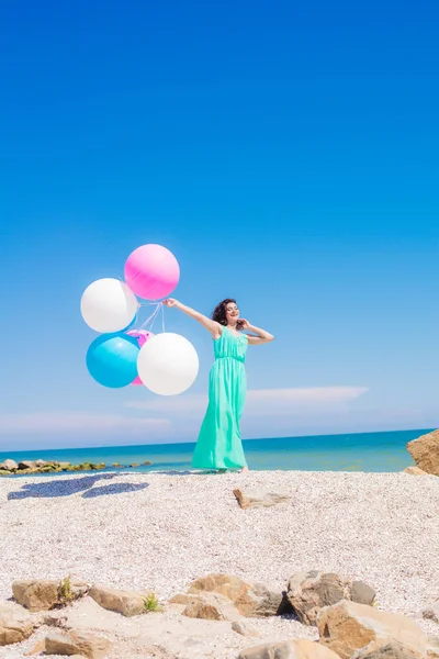 Krásná dívka na pláži s barevnými balónky — Stock fotografie