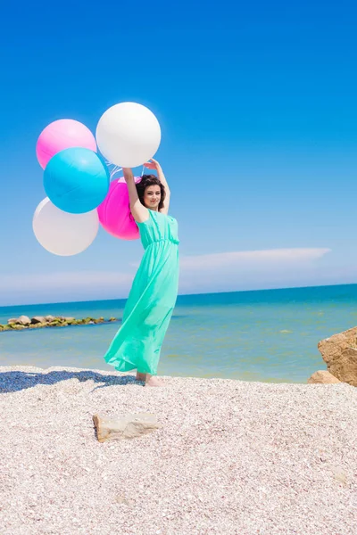 Krásná dívka na pláži s barevnými balónky — Stock fotografie