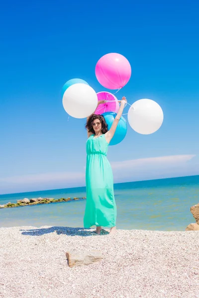 Krásná dívka na pláži s barevnými balónky — Stock fotografie