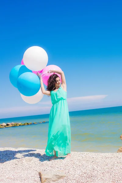 Menina bonita na praia com balões coloridos — Fotografia de Stock
