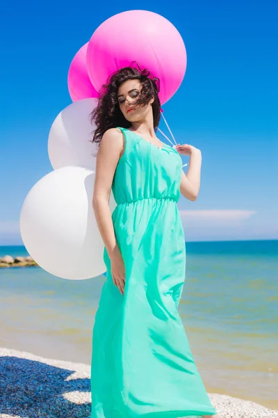 Beautiful girl on the beach with colorful balloons — Stock Photo, Image