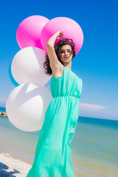 Menina bonita na praia com balões coloridos — Fotografia de Stock