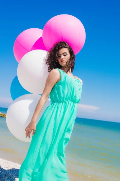 Beautiful girl on the beach with colorful balloons — Stock Photo, Image