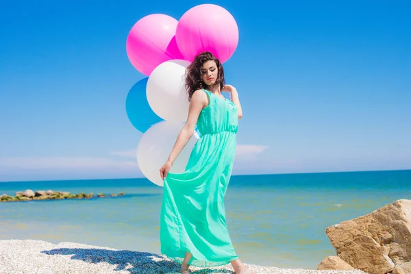 Menina bonita na praia com balões coloridos — Fotografia de Stock