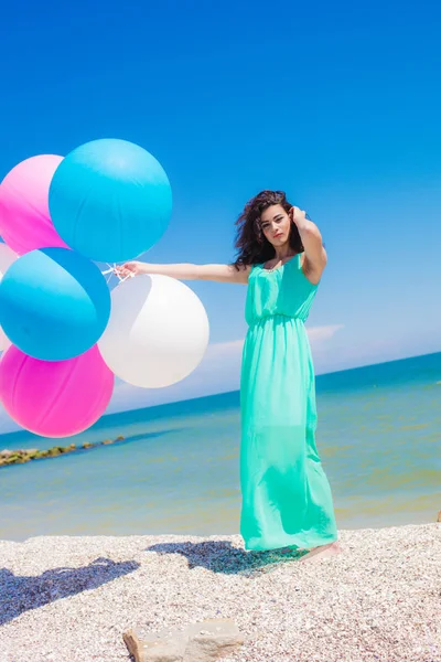 Beautiful girl on the beach with colorful balloons — Stock Photo, Image