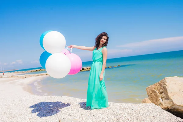 Krásná dívka na pláži s barevnými balónky — Stock fotografie