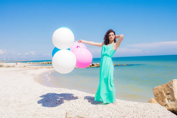 Menina bonita na praia com balões coloridos — Fotografia de Stock