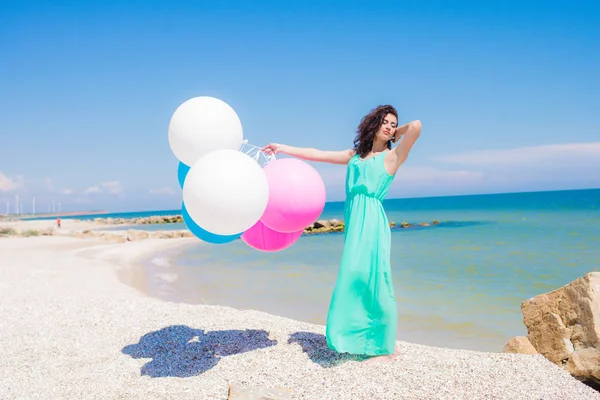 Menina bonita na praia com balões coloridos — Fotografia de Stock