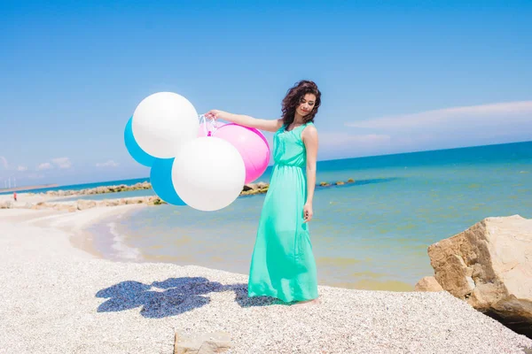 Menina bonita na praia com balões coloridos — Fotografia de Stock