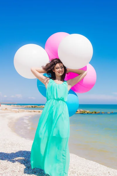 Hermosa chica en la playa con globos de colores —  Fotos de Stock