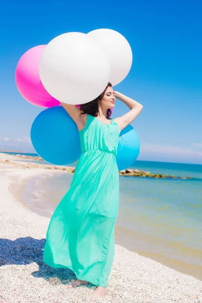 Όμορφο κορίτσι στην παραλία με τα πολύχρωμα μπαλόνια — Φωτογραφία Αρχείου