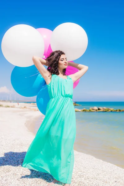 Vacker flicka på stranden med färgglada ballonger — Stockfoto