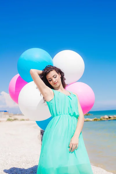 Vacker flicka på stranden med färgglada ballonger — Stockfoto