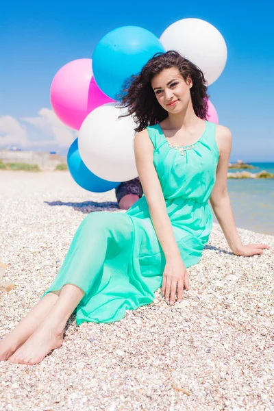 Belle fille sur la plage avec des ballons colorés — Photo