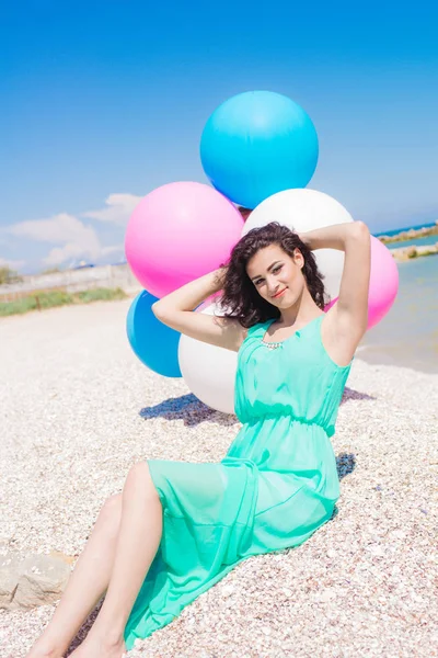 Menina bonita na praia com balões coloridos — Fotografia de Stock