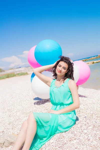 Menina bonita na praia com balões coloridos — Fotografia de Stock