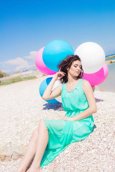 Menina bonita na praia com balões coloridos — Fotografia de Stock