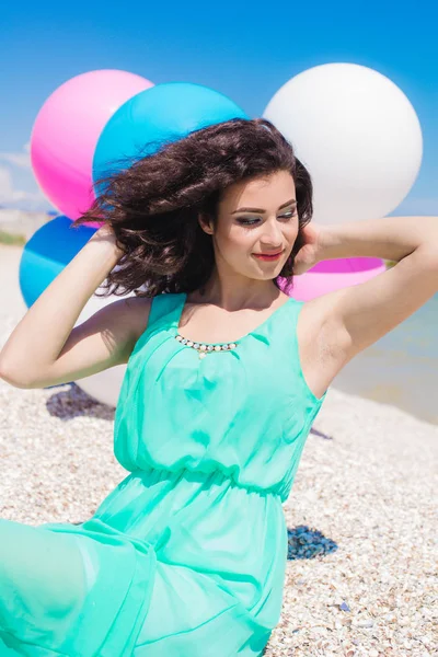 Красива дівчина на пляжі з різнокольоровими повітряними кулями — стокове фото