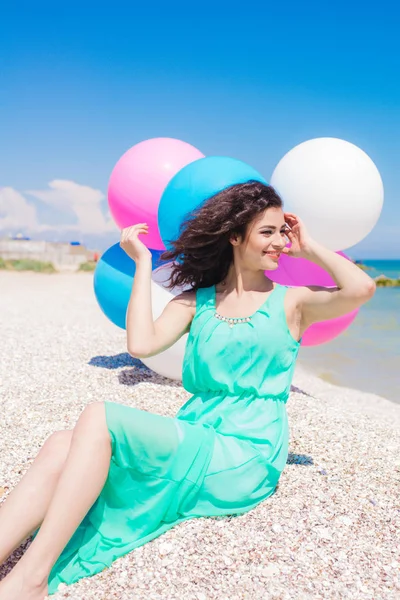 Menina bonita na praia com balões coloridos — Fotografia de Stock