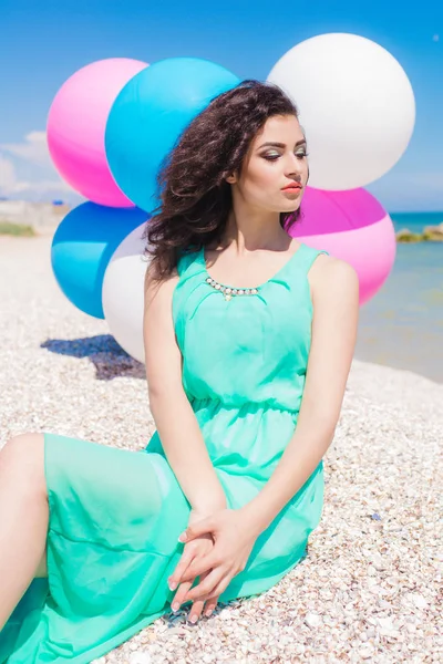 Mooi meisje op het strand met kleurrijke ballonnen — Stockfoto