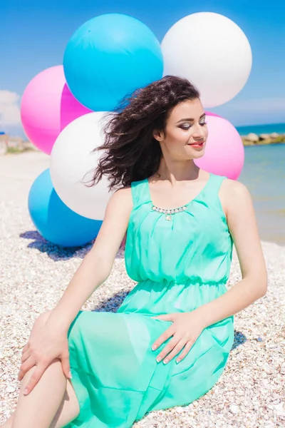 Menina bonita na praia com balões coloridos — Fotografia de Stock