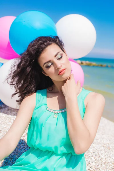 Красива дівчина на пляжі з різнокольоровими повітряними кулями — стокове фото