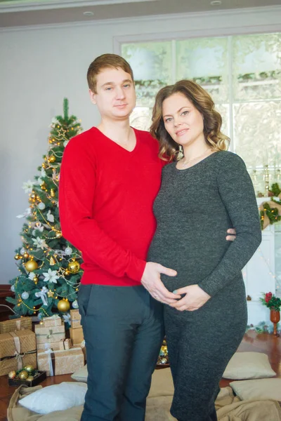 Schöne Schwangere Verliebte Pärchen Vor Dem Hintergrund Eines Weihnachtsbaums Die — Stockfoto