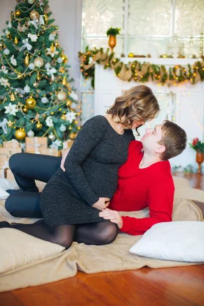 Schöne Schwangere Verliebte Pärchen Vor Dem Hintergrund Eines Weihnachtsbaums Die — Stockfoto