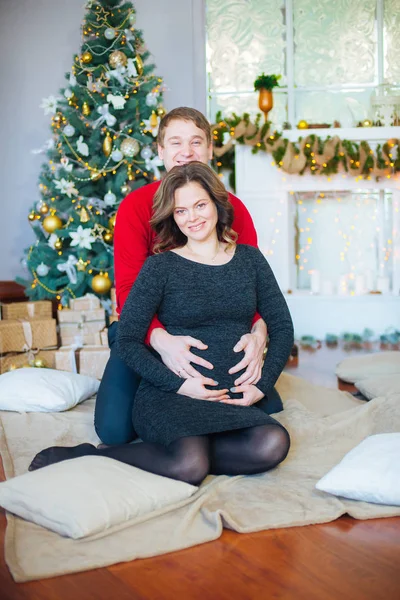 Schöne Schwangere Verliebte Pärchen Vor Dem Hintergrund Eines Weihnachtsbaums Die — Stockfoto