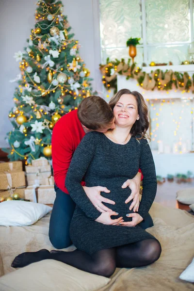 Schöne Schwangere Verliebte Pärchen Vor Dem Hintergrund Eines Weihnachtsbaums Die — Stockfoto