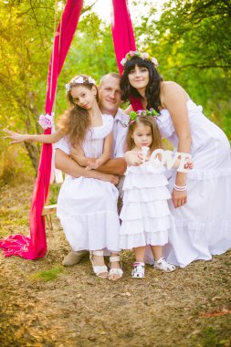 Mutlu ebeveynler ve çocuklar salıncakta gün batımında bir buğday tarlası yaz açık havada eğlenmek